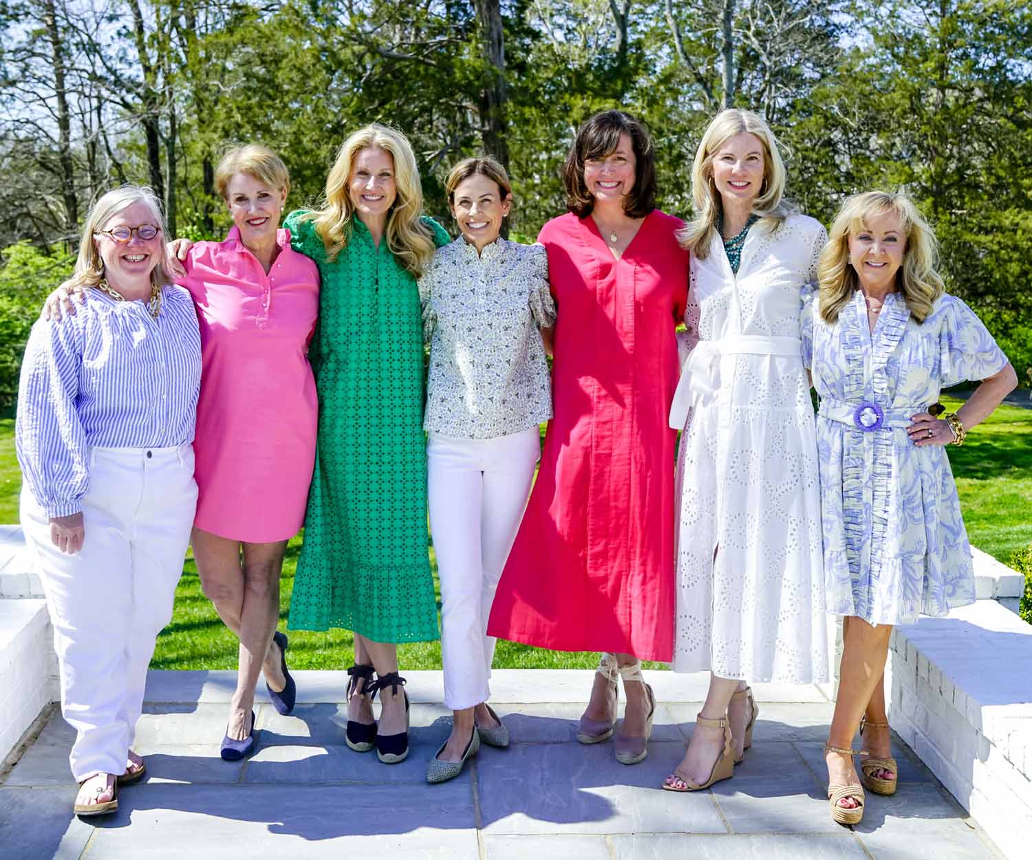 The ladies of Mahjong & Magnolias smiling on a bright sunny day, wearing bright colorful clothes