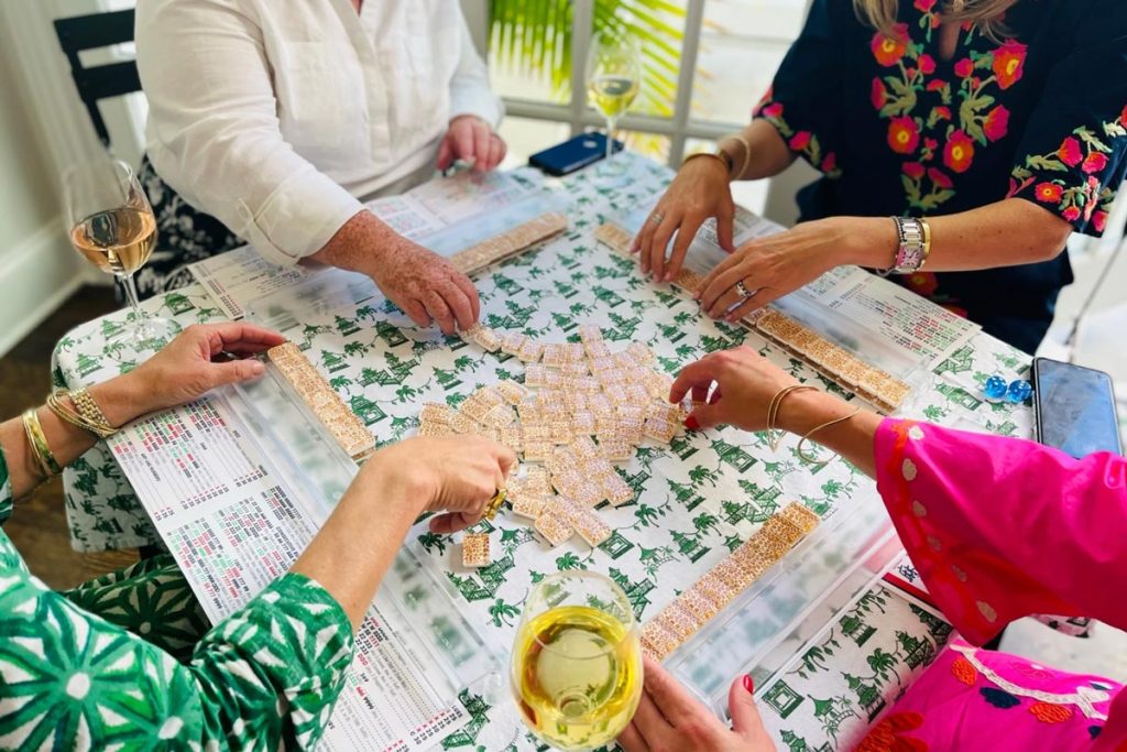 four ladies playing mahjong with colorful tiles