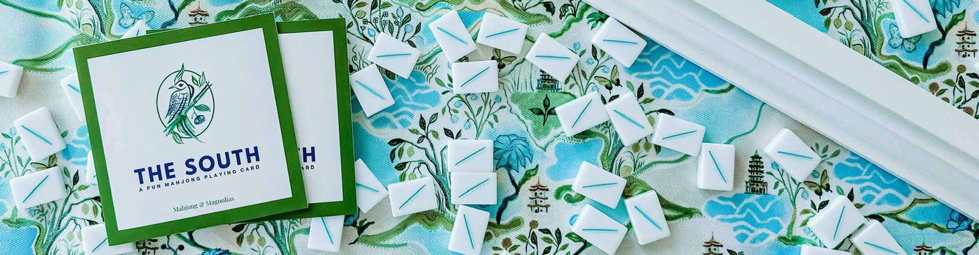 Colorful mahjong tiles scattered on a table ready for play with the South themed mahjong playing card from Mahjong & Magnolias
